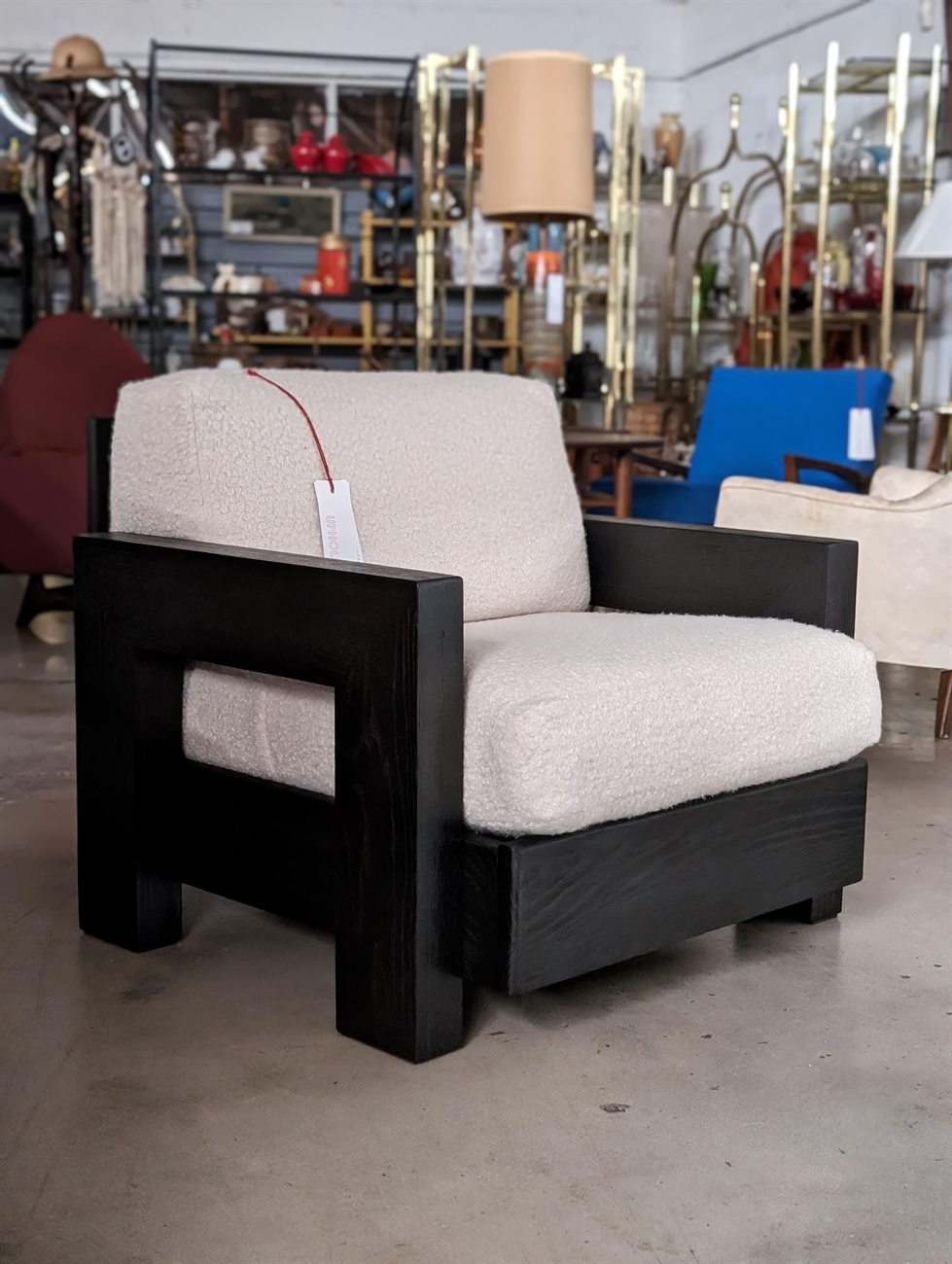The same lounge chair after restoration in ebony and cream bouclé