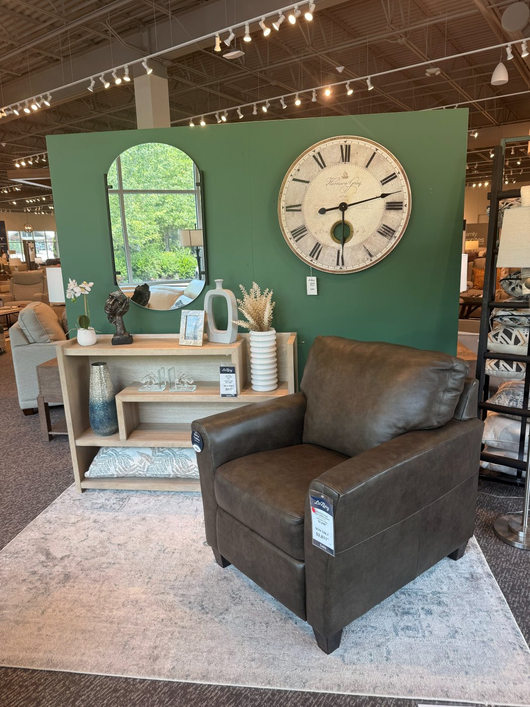 Espresso leather chair staged against a green vignette